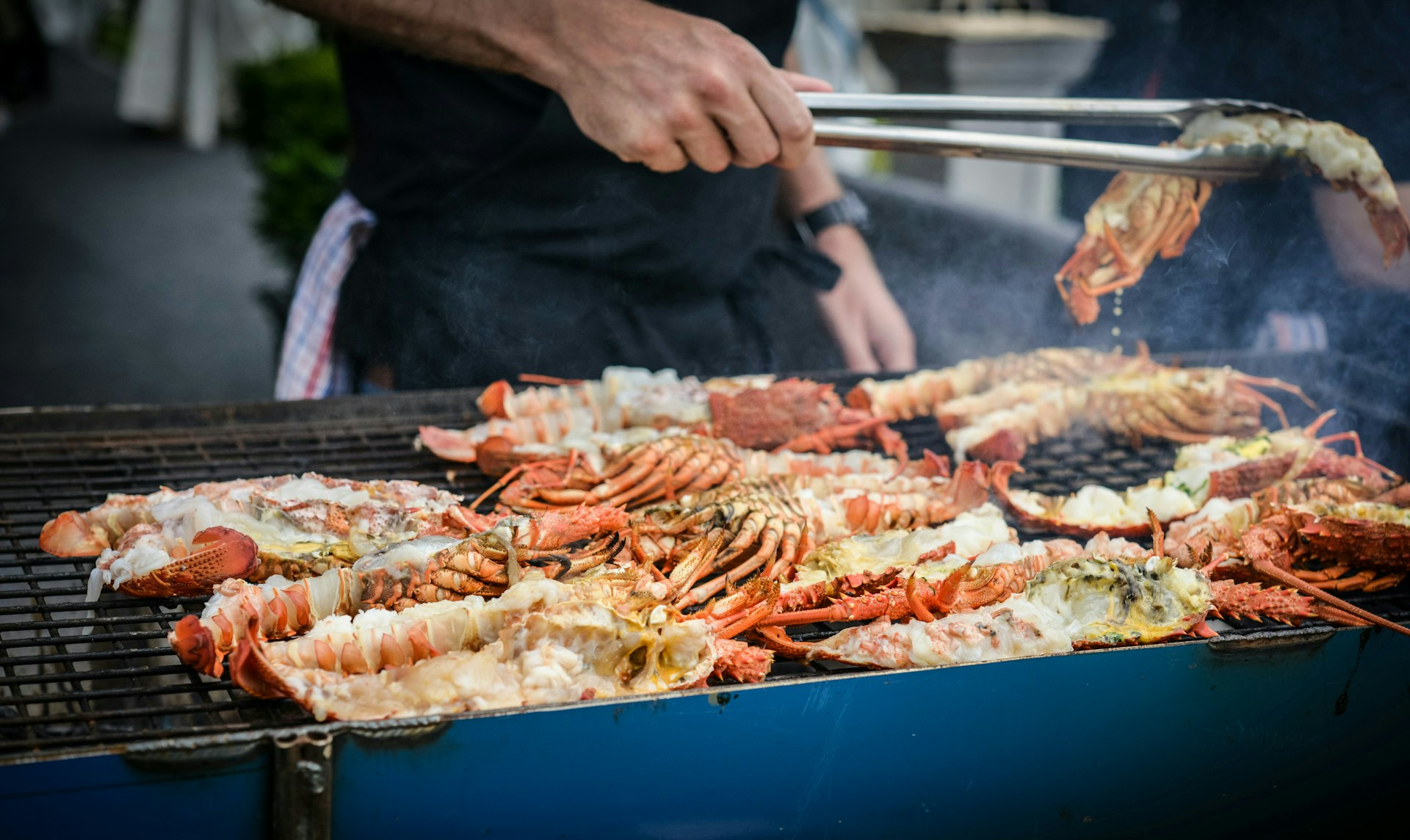 man grilling crabs during daytime